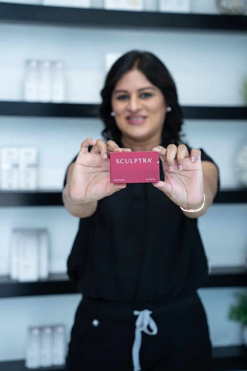 A Medrein Health team member holding a carton of Sculptra poly-L-lactic acid collagen biostimulator at the clinic in Southlake, TX