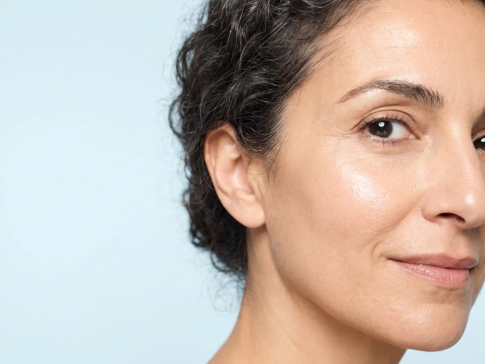 Clear, even, refreshed skin across the cheek and outer eye of a woman in her fifties, the smoother tone and texture laser resurfacing works toward across the whole face