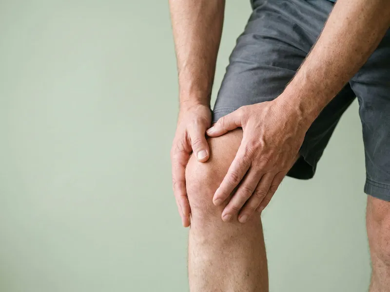 A man holding his knee with both hands.