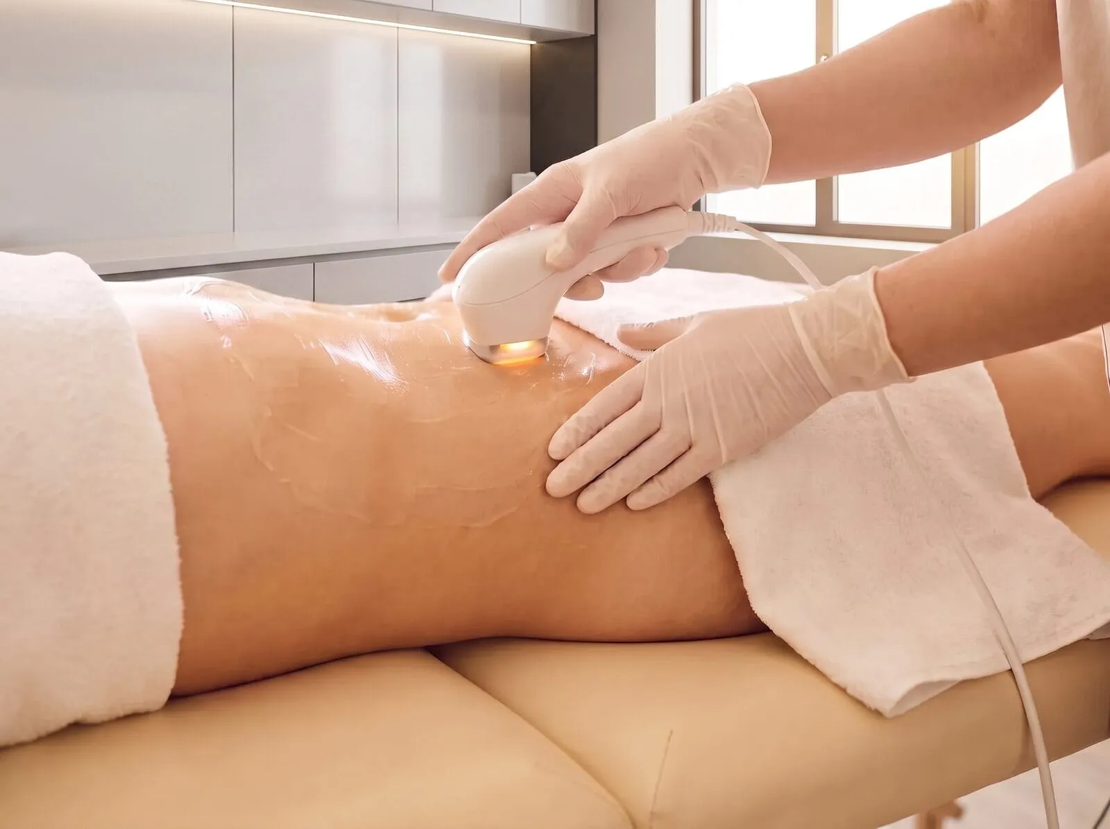 A patient having a TightSculpting laser pass performed on the abdomen in a treatment room